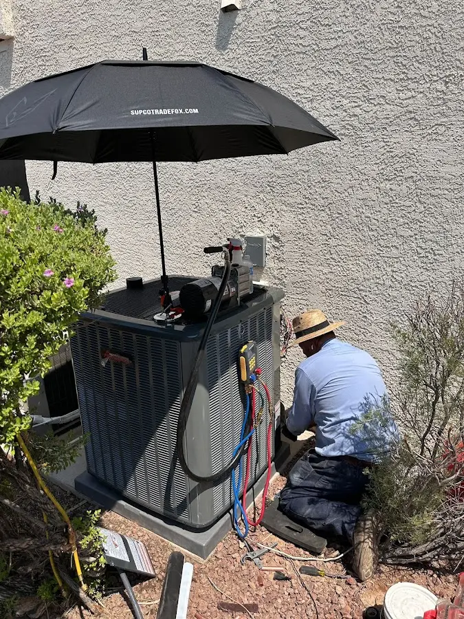 HVAC technician performing outdoor AC maintenance in Williamsburg